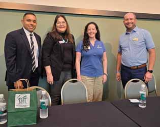 Four panel members standing behind the table