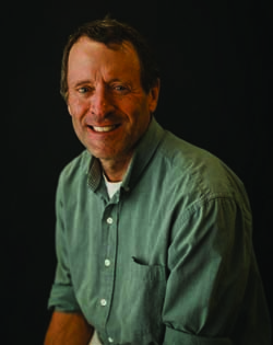 Dr. Roserner in sage green polo shirt on dark backgroung