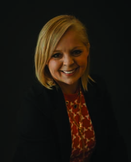 Dr. Tena Wooldridge Headshot dark blazer and patterned blouse